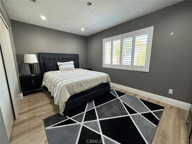 a bedroom with a bed and wooden floor