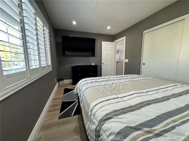 a spacious bedroom with a bed and a flat screen tv