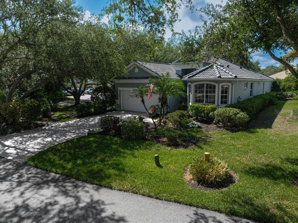 103 Bishopscourt Road Osprey, FL 34229 - Photo 32 of 55 a front view of a house with a garden and trees