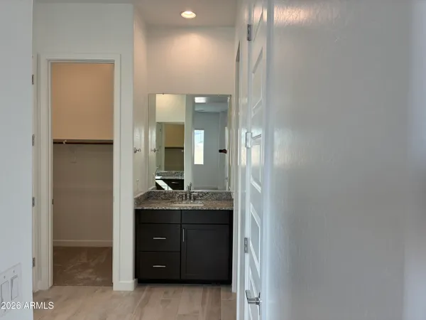 a bathroom with a granite countertop sink a mirror and a shower
