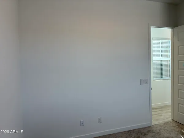 a view of an empty room with window and closet area