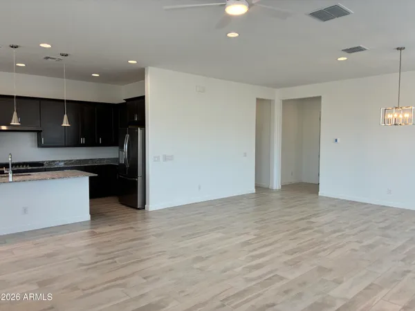 a view of kitchen with kitchen island granite countertop a stove top oven a sink and a counter top space