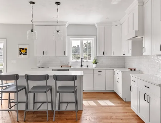 a kitchen with stainless steel appliances granite countertop a white cabinets and wooden floor
