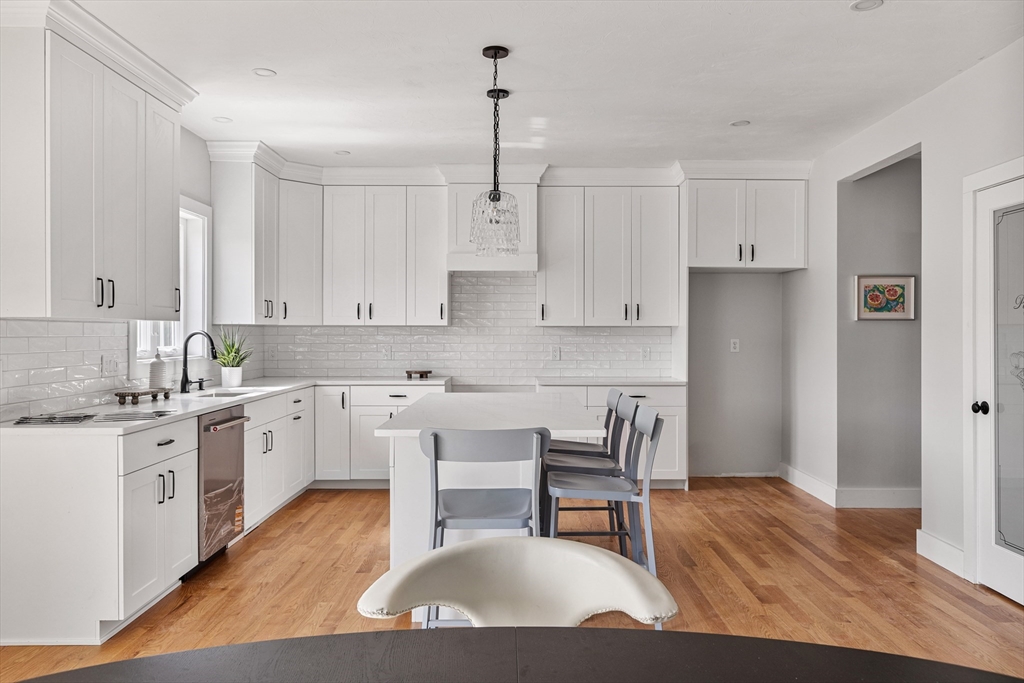 6 April Way Millis, MA 02054 - Photo 13 of 37 a kitchen with stainless steel appliances granite countertop a white cabinets and wooden floor