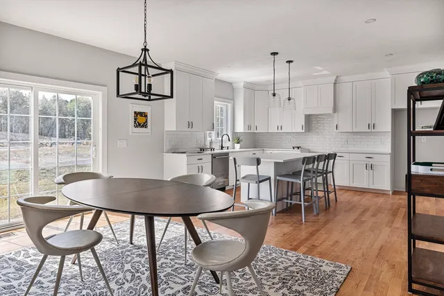 a kitchen with stainless steel appliances granite countertop a dining table chairs and granite counter tops