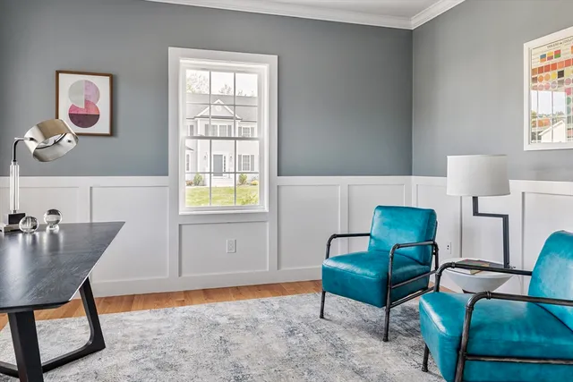 a living room with stainless steel appliances wooden floor and window
