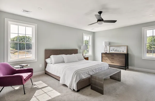a bedroom with a bed a chandelier and windows