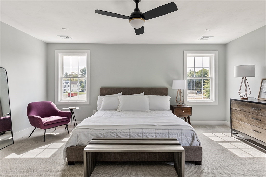 6 April Way Millis, MA 02054 - Photo 27 of 37 a bedroom with a bed a chandelier and windows