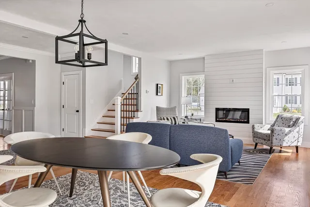 a view of a hallway with wooden floor and dining room view
