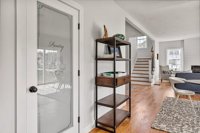 a kitchen with stainless steel appliances kitchen island a white table chairs and a refrigerator