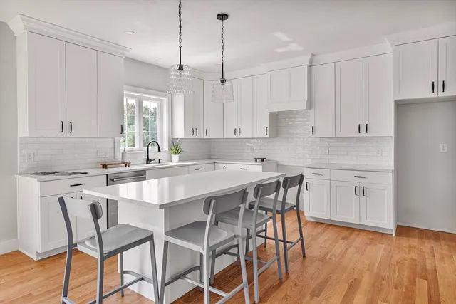 a kitchen with white cabinets a sink and a window