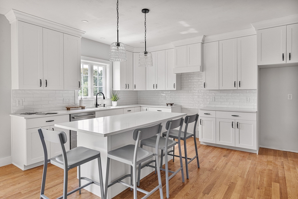 6 April Way Millis, MA 02054 - Photo 9 of 37 a kitchen with stainless steel appliances kitchen island a white table chairs and a refrigerator