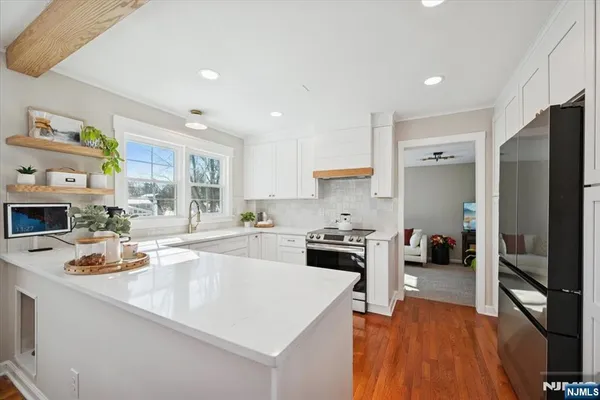 a kitchen with stainless steel appliances a stove a sink a refrigerator and cabinets