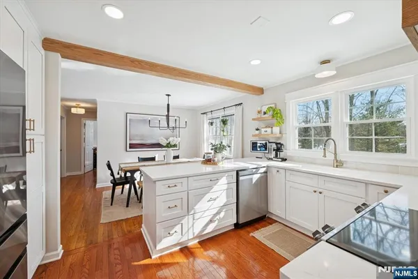 a large white kitchen with sink and cabinets