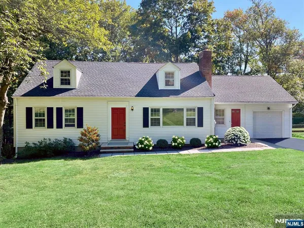 a front view of a house with a garden and yard