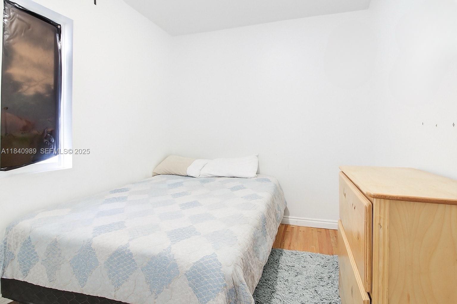 1745 Northwest 49th Street Miami, FL 33142 - Photo 12 of 30 a bedroom with a bed and a mirror