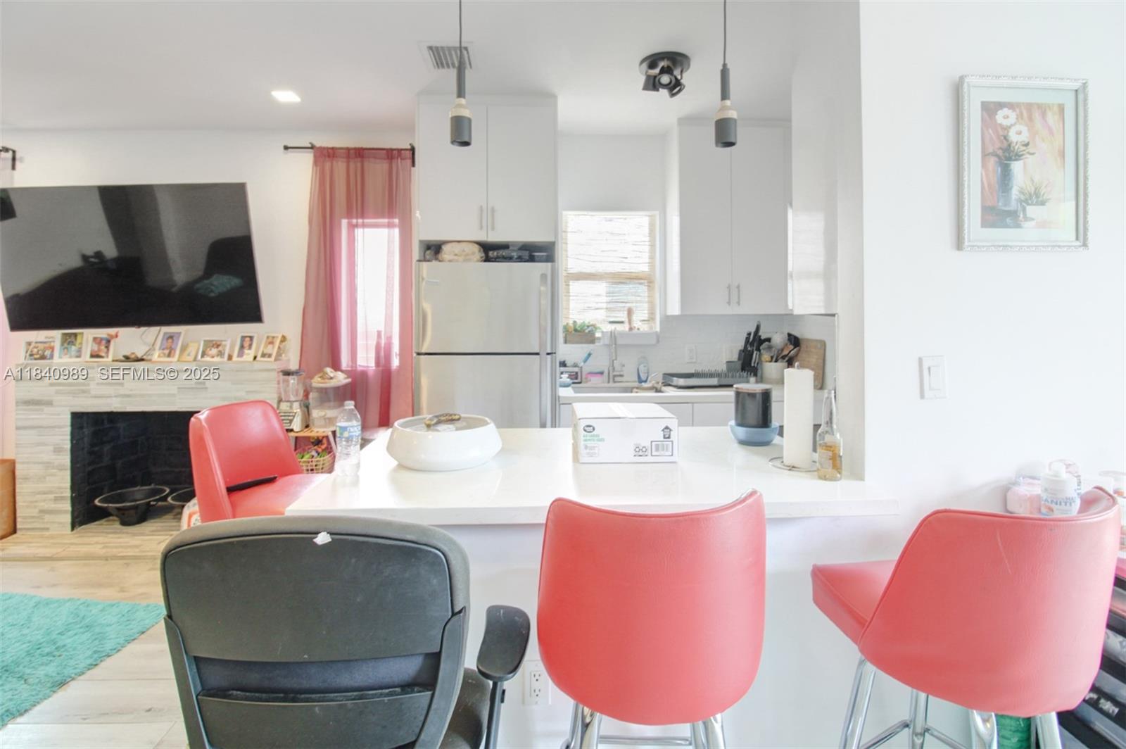 1745 Northwest 49th Street Miami, FL 33142 - Photo 14 of 30 a living room with furniture a fireplace and a flat screen tv