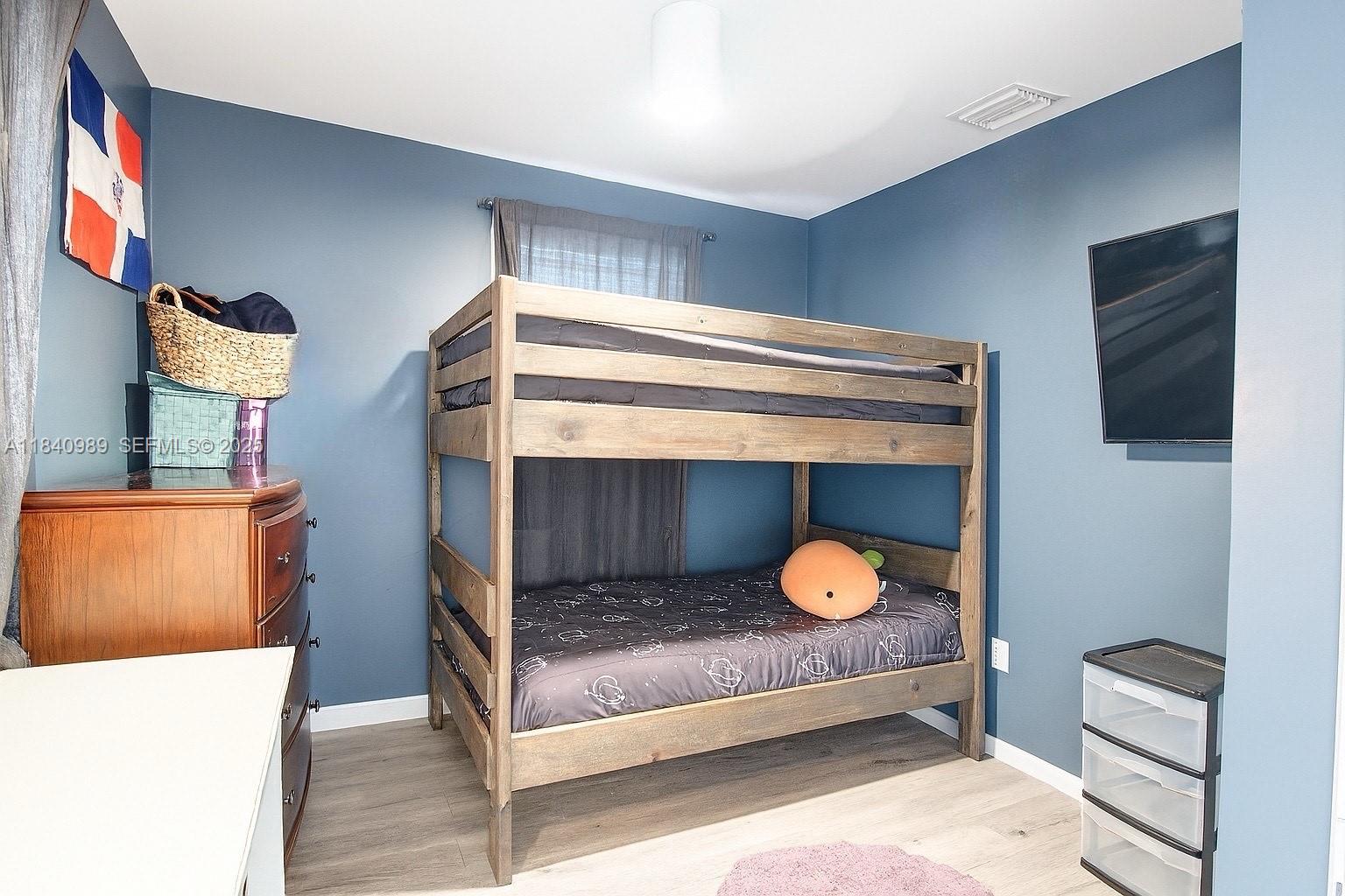 1745 Northwest 49th Street Miami, FL 33142 - Photo 18 of 30 a bedroom with a bed and a flat screen tv