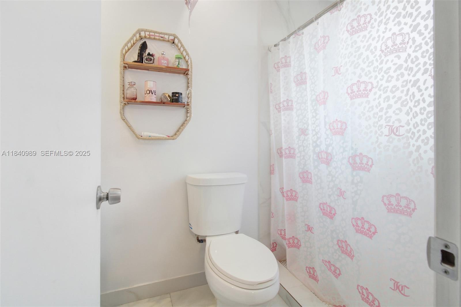 1745 Northwest 49th Street Miami, FL 33142 - Photo 19 of 30 a white toilet sitting next to a shower curtain