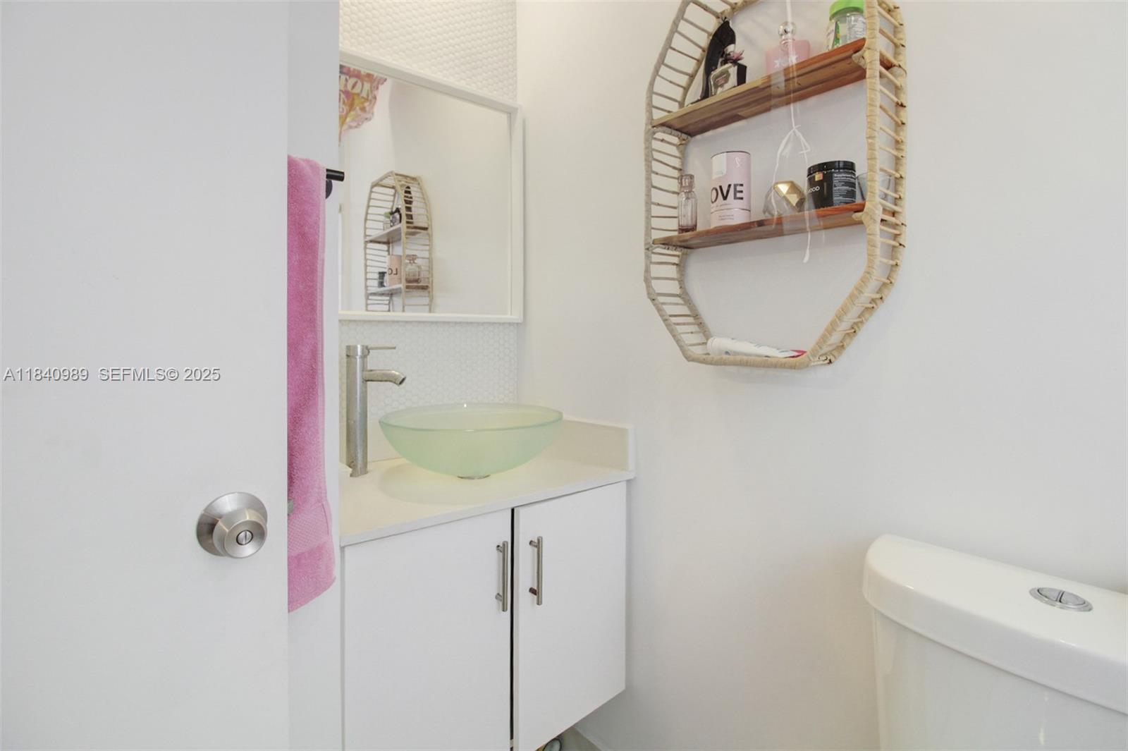 1745 Northwest 49th Street Miami, FL 33142 - Photo 20 of 30 a bathroom with a granite countertop sink a toilet and a mirror