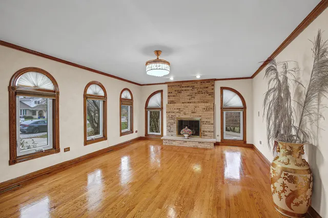 a view of a livingroom with fireplace window and wooden floor