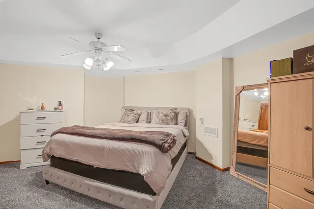 a spacious bedroom with a bed and a cabinets