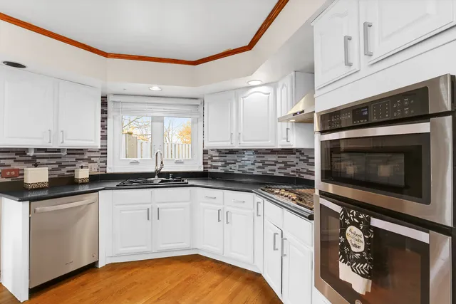 a kitchen with granite countertop white cabinets and white appliances