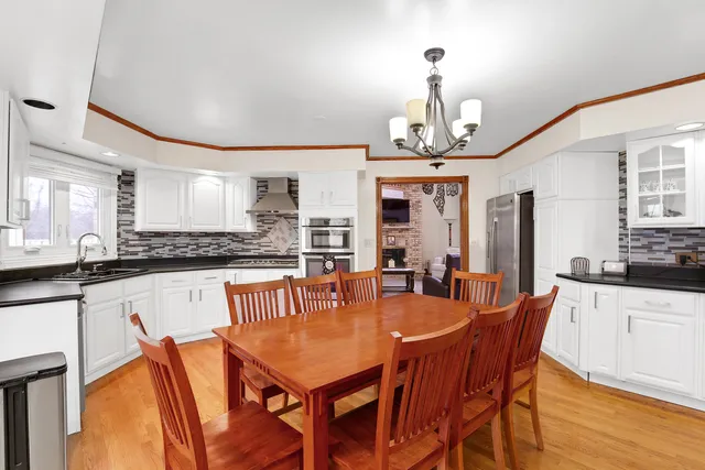 a dining table with chairs and kitchen view