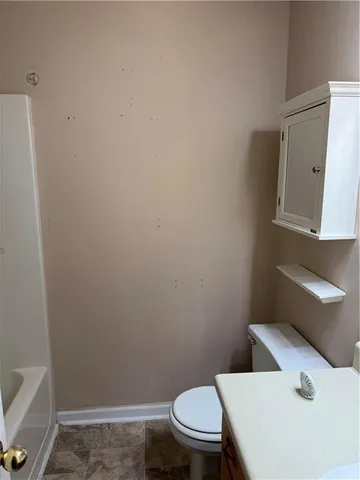 a white toilet sitting next to a white sink