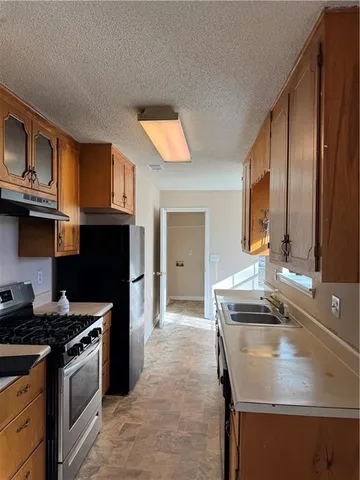 a kitchen with stainless steel appliances granite countertop a stove a sink and a microwave