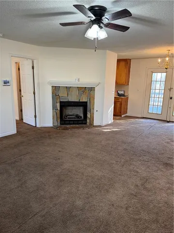 a view of an empty room with a fireplace and a window