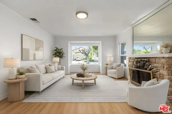 a living room with furniture a fireplace and a large window