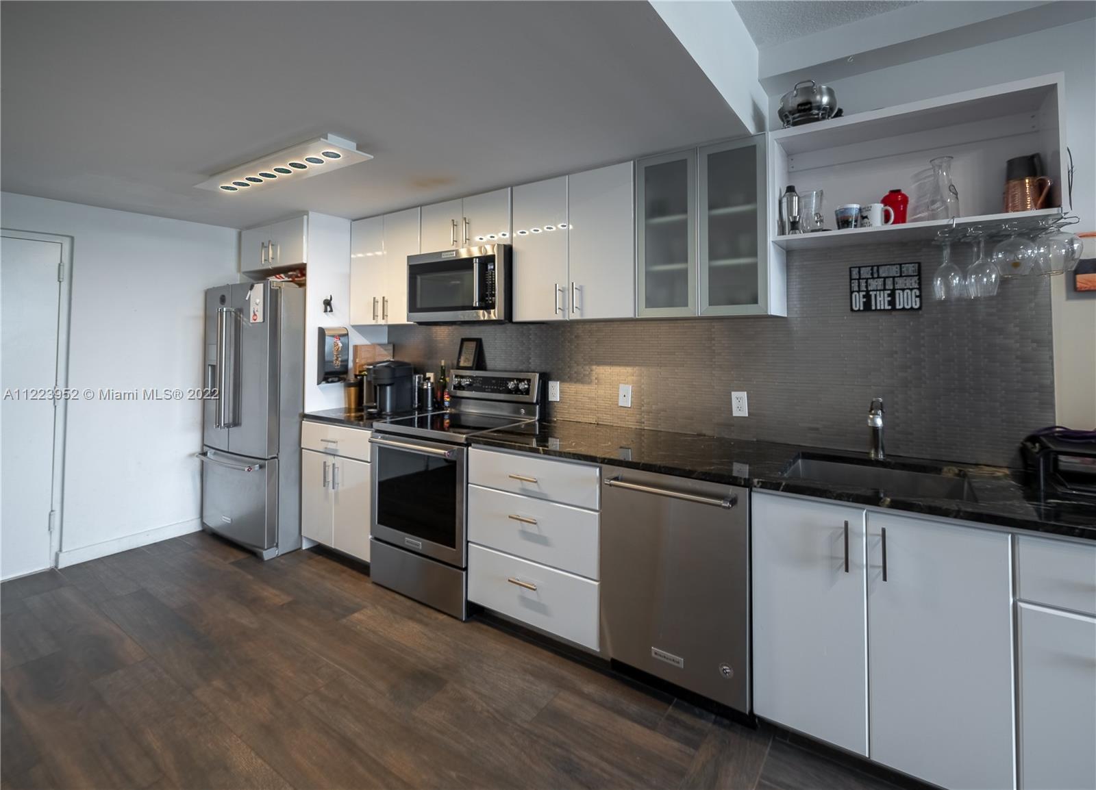 3339 Virginia Street, Unit 339 Miami, FL 33133 - Photo 1 of 13 a kitchen with granite countertop a refrigerator and a sink