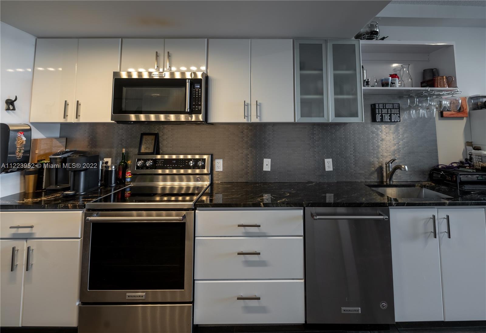 3339 Virginia Street, Unit 339 Miami, FL 33133 - Photo 2 of 13 a kitchen with stainless steel appliances granite countertop a stove and a microwave