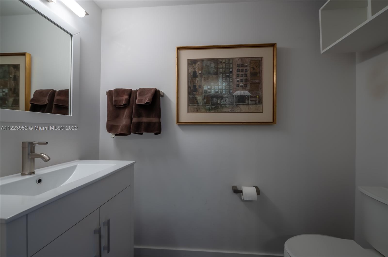 3339 Virginia Street, Unit 339 Miami, FL 33133 - Photo 4 of 13 a bathroom with a toilet a sink and mirror