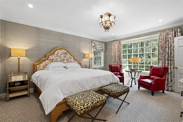 a bedroom with a bed and a flat tv screen next to a window