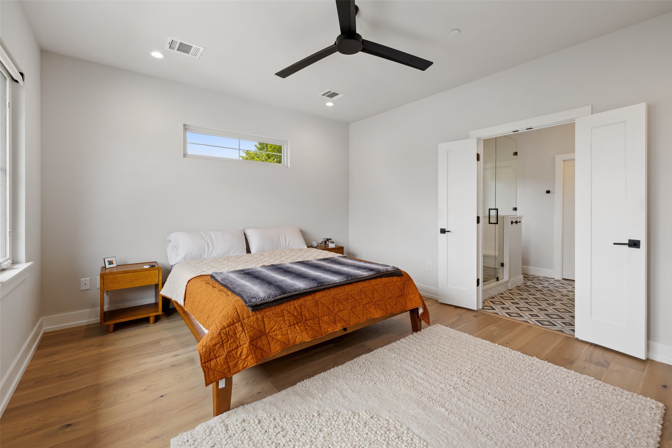 1504 Ruth Avenue, Unit 3 Austin, TX 78757 - Photo 20 of 39 A tranquil bedroom retreat features rich wood flooring, a contemporary ceiling fan, and access to an adjacent primary bath.