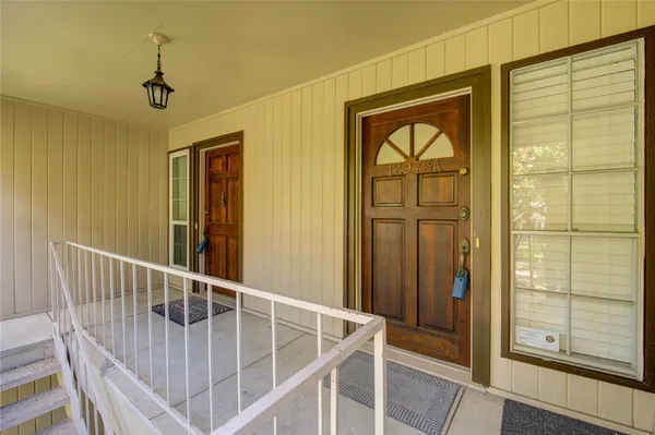 a view of a hallway with wooden floor and windows