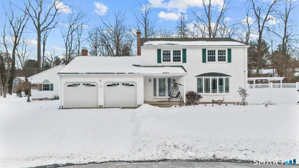 a view of a white house with a yard covered in snow