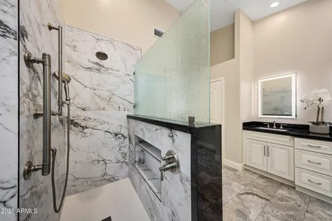 a bathroom with a granite countertop sink and a mirror