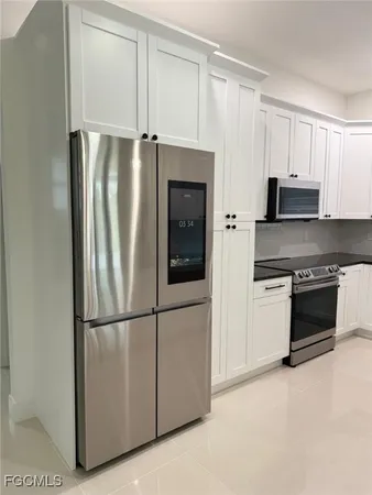 a kitchen with granite countertop a sink and white cabinets