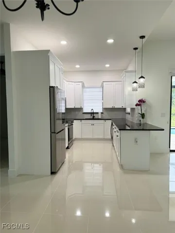 a view of kitchen with white cabinets and a stove