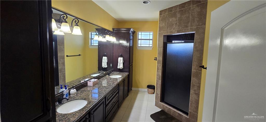 5312 Mile 4 Road Mission, TX 78573 - Photo 9 of 13 Bathroom featuring double vanity, light tile patterned floors, and a stall shower