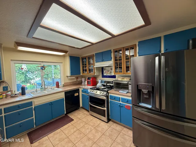 a kitchen with stainless steel appliances granite countertop a refrigerator a sink dishwasher a stove and a refrigerator