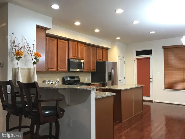 a kitchen with stainless steel appliances granite countertop a sink refrigerator and microwave