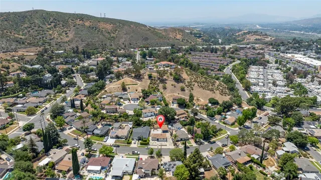 an aerial view of a houses with a lush green hillside