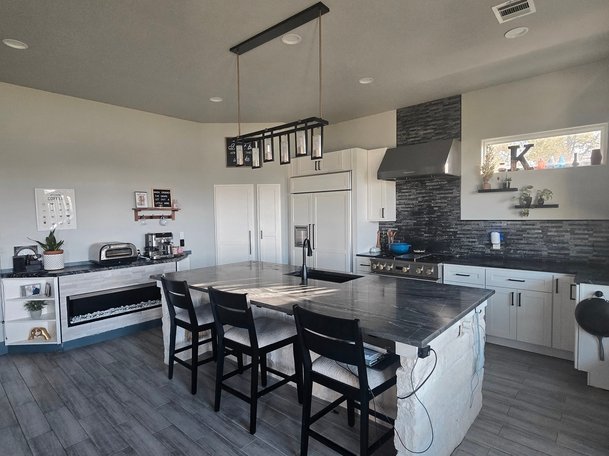 206 Elm Street Highlands, TX 77562 - Photo 6 of 9 a kitchen with granite countertop a table chairs stove and wooden floor