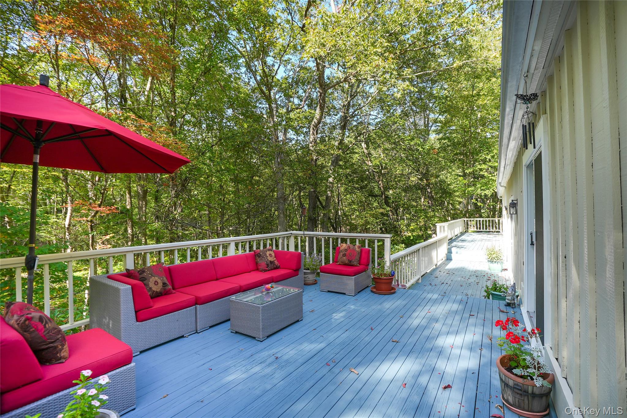 22 Peters Lane Pound Ridge, NY 10576 - Photo 37 of 43 Expansive blue-painted deck with white railings and mature tree backdrop