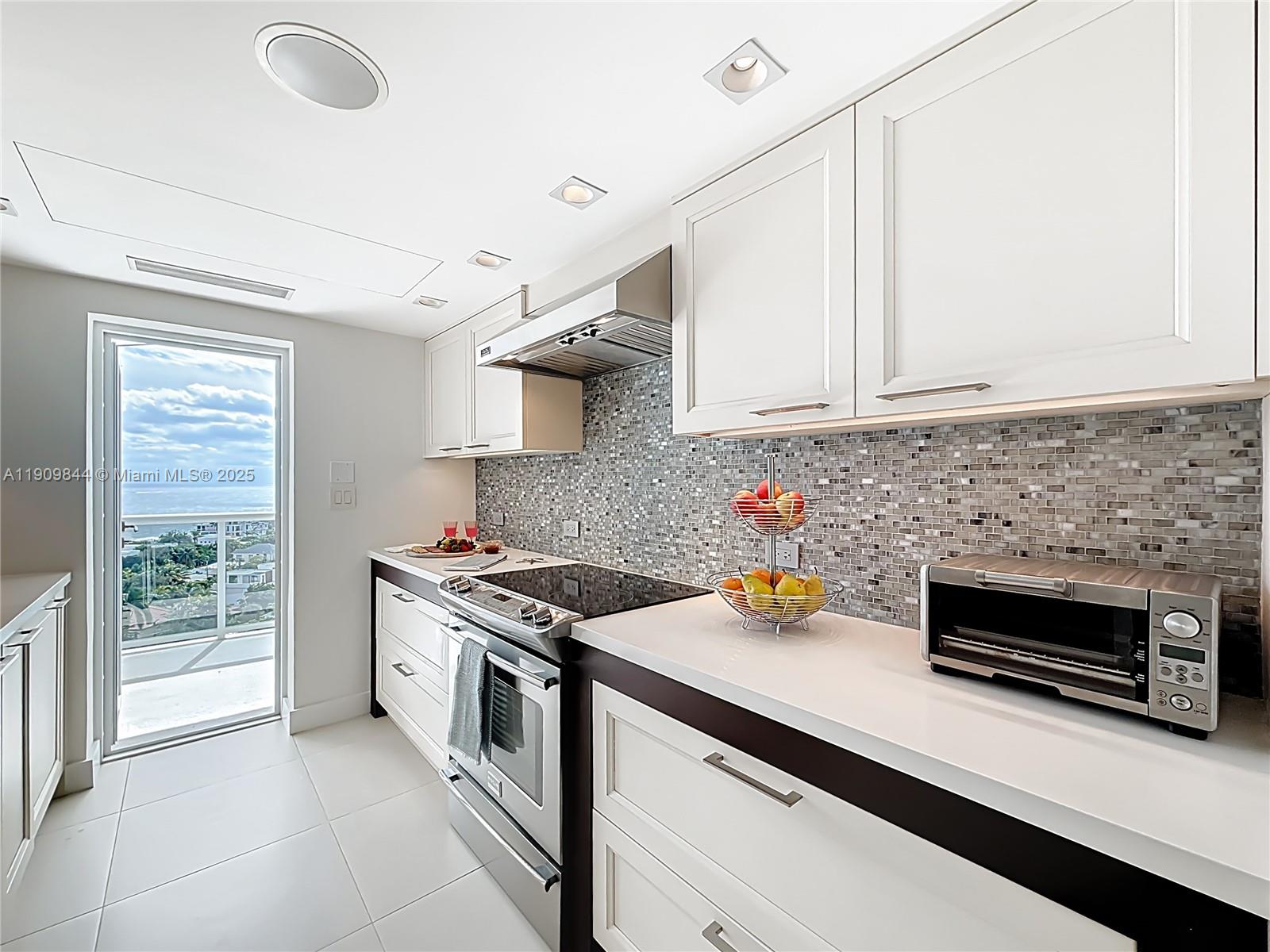2715 North Ocean Boulevard, Unit 15D Fort Lauderdale, FL 33308 - Photo 15 of 57 a kitchen with stainless steel appliances a stove a sink and a white cabinets