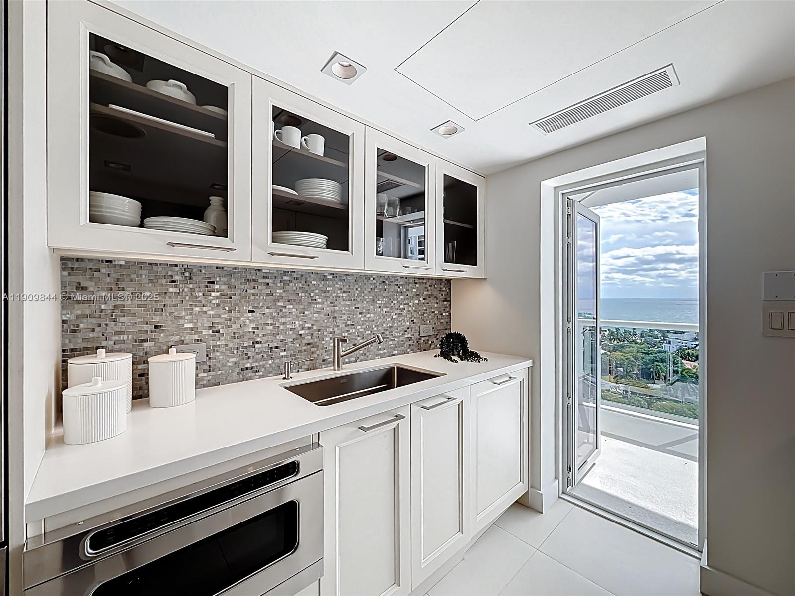 2715 North Ocean Boulevard, Unit 15D Fort Lauderdale, FL 33308 - Photo 19 of 57 a kitchen with a sink and large cabinets